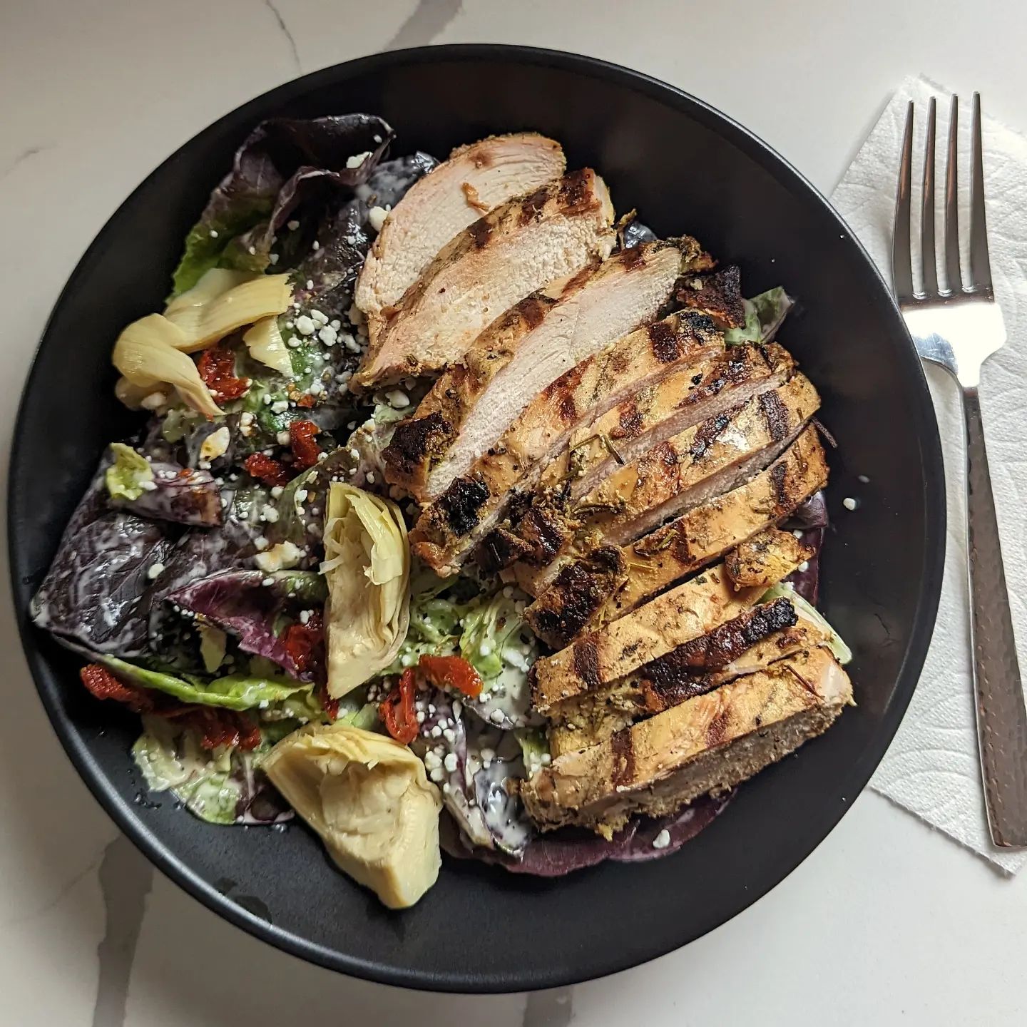 Lemon Herb Chicken SaladThe shining star in this salad is the @brandingironranch lemon herb chicken. Grilled at 350 to an internal temp of 165 using @bearmountainbbq bourbon blend pellets over an open fire. I made this chicken the day before so it could be served cold over the salad.The salad base is a butter lettuce blend tossed in @chosenfoods ranch dressing, a touch of feta cheese and some @spiceology Greek freak seasoning. The salad is then topped with a few sundried tomatoes and marinated artichoke hearts. A salad pro tip: add your favorite seasoning or rub to your salads! You do not need to stick to fresh cracked pepper or no seasoning at all. A little bit of seasoning goes a long way on fresh lettuce! With the chicken prepared in advance this top tier restaurant quality salad comes together very quickly and easily for the perfect lunch. #salad #saladrecipe #salads #grilledchicken #bearmountainbbq #foodphotography #healthyrecipes #eathealthy #lunchideas