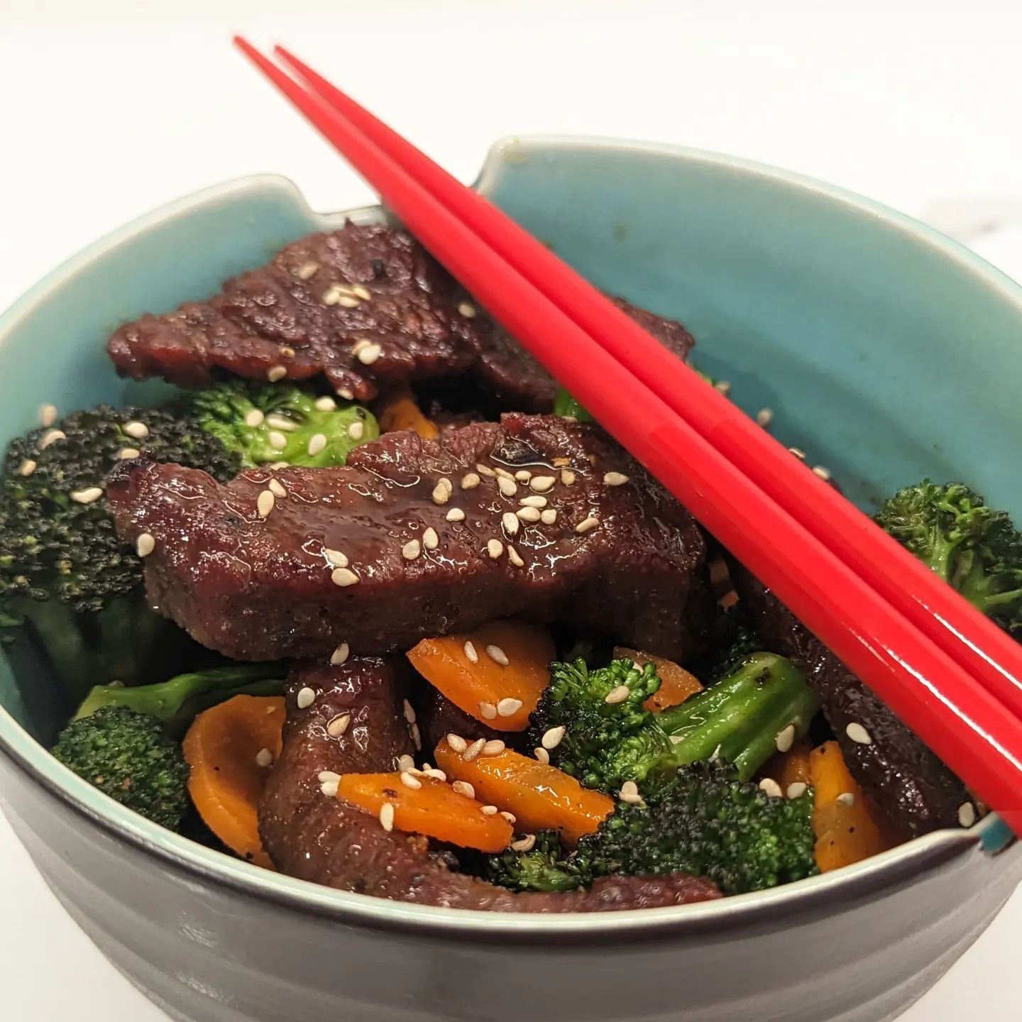 Keto friendly Beef and BroccoliThis starts with velveting some flank steak (toss beef in baking soda for 30 min, rinse and pat dry) then seasoning the steak with @neilsarap asian rub and cooking over medium high heat in some @chosenfoods avocado oil.In a separate pan, some broccoli and carrots were seasoned and sauteed in the same way. For the sauce, I used a brown sauce recipe from @stepawayfromthecarbs swapping the fish sauce for Trader joes umami seasoning and I used @swervesweetie brown sugar. I would probably cut the sugar in half next time. To plate, I tossed the beef in a bit of the sauce, drizzled a little more sauce over the veggies, and garnished with a few sesame seeds. #beefandbroccoli #chinesefood #takeout #homerecipe #ketofood #ketorecipes #lowcarb