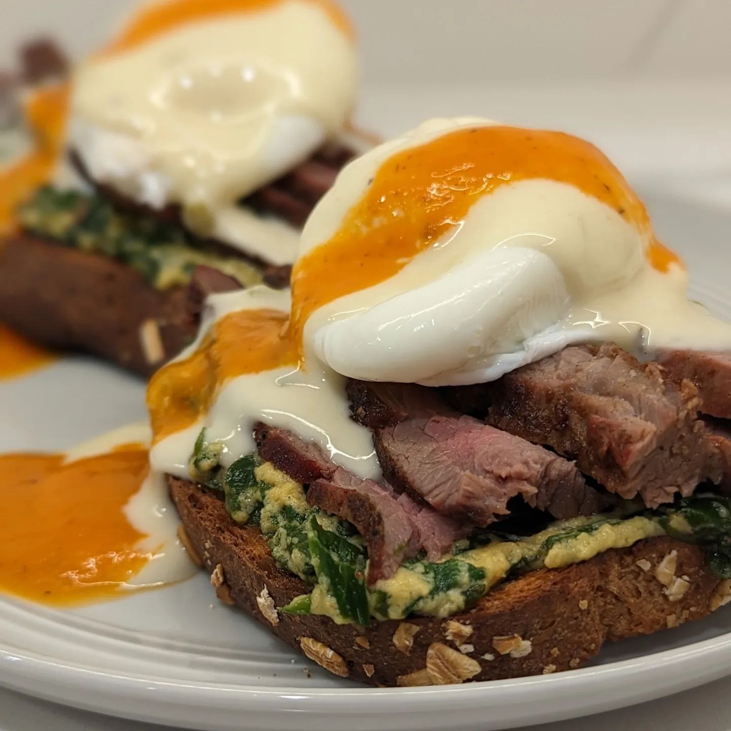 Steak and Eggs BenedictThe addiction is real, so I made another one last night for dinner. We'll start at the bottom and work our way up. @carbonautbaking keto friendly bread, buttered and toasted. Fresh spinach sauteed in some leftover hollandaise (great way to stretch a bit of hollandaise and make it have an impact) Smoked flank steak leftovers, warmed up in butter. Originally smoked with @bearmountainbbqApple wood pellets. Warming it up brought out an amazing smoke aroma and absolutely flavored the butter, which I used for the toast and then sauteed the spinach in the same pan. Poached egg. White queso from Costco, and finally a bit of habanero hot sauce. What a treat! This one was over the top delicious! #eggsbenedict #brunch #breakfast #ketofood #poachedeggs #lowcarb #eggs #hollandaise