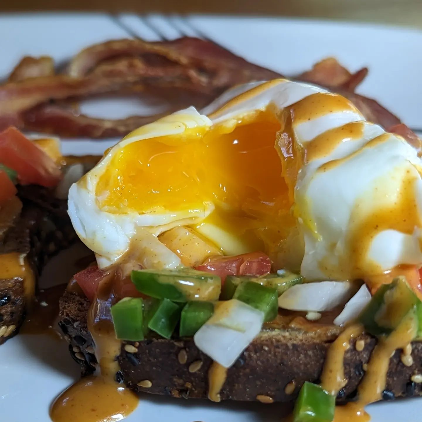 Poached eggs over toastThis poached egg is garnished with @terrapinridgefarms chipotle sauce and served over fresh pico on a cheese crusted @carbonautbaking bread. Served with a side of bacon for good measure!#poachedegg #eggs #eggporn #bacon #brunch #breakfast #lowcarb #yummyfood