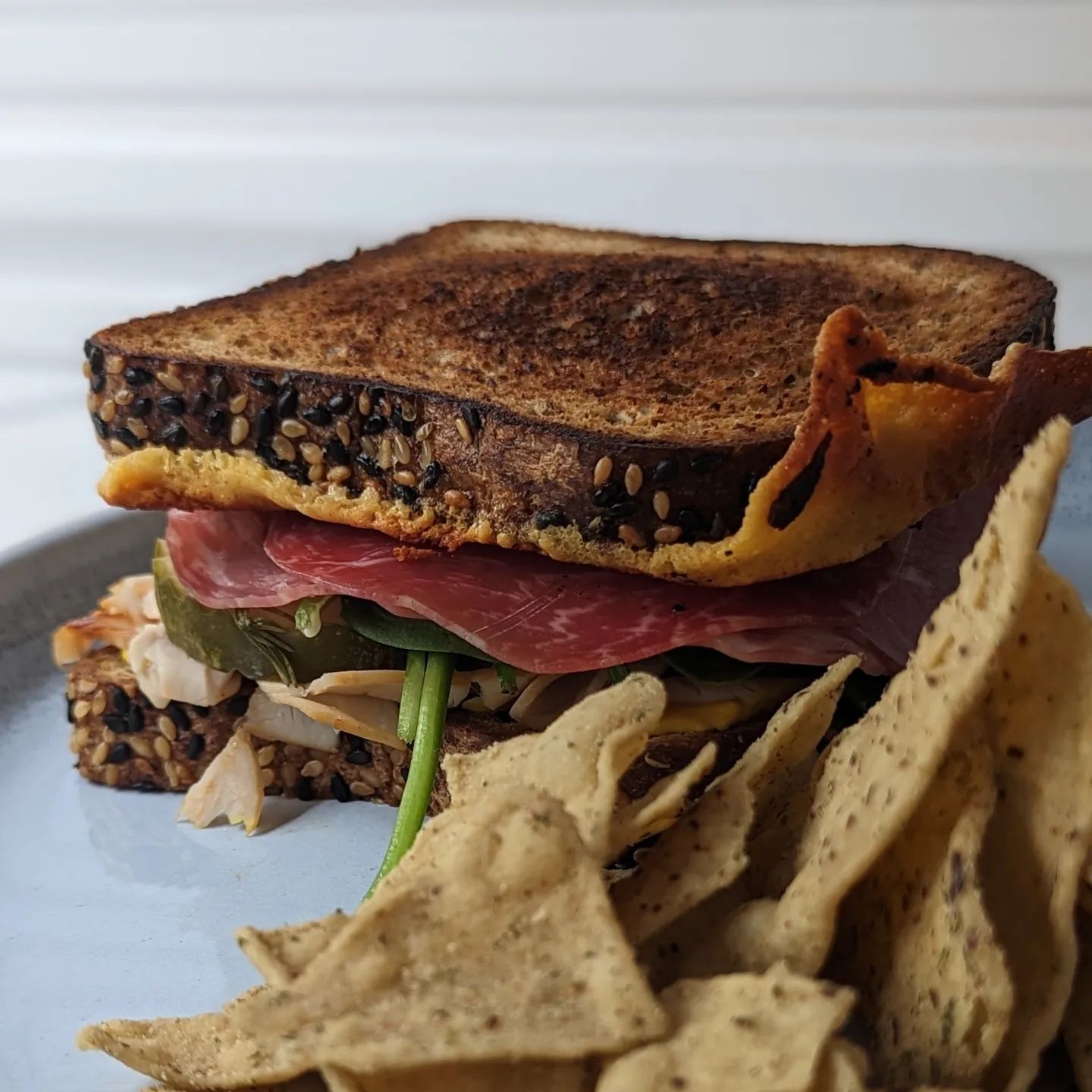 Turkey Italian sandwich with chips!Not all meals are fancy, but some sandwiches are fancier than others!I started by toasting some @carbonautbaking bread with a touch of butter. Then on one side I melted a thick cut piece of cheddar cheese before flipping it over to get that nice crispy cheese skirt. I threw the turkey right on the griddle to arm it alongside some baby spinach. Then I built the sandwich layering some mustard, @chosenfoods mayo, the turkey, pickles, spinach, salami, capicola and that cheese crusted bread.Served up with a side of @hilolifesnacks ranch chips and I was set!!#sandwich #turkeysandwich #lowcarb #ketosandwich #chips #lunch #lunchideas