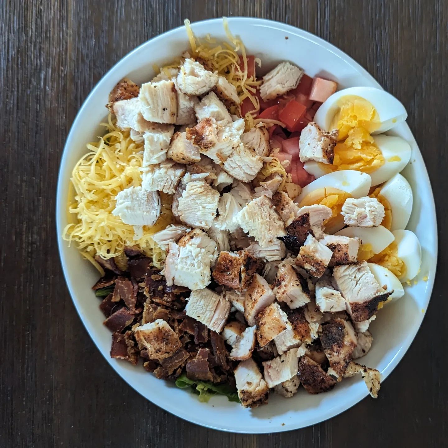 Simple cobb saladBacon, egg, grilled chicken breast, tomato and cheese over a bed of mixed greens and Romain tossed in ranch dressing. @neilsarap gourmet lemon pepper on the chicken@bearmountainbbq bourbon blend pellets@tillamook cheddar cheeseHome cured bacon@litehousefoods honestly ranch