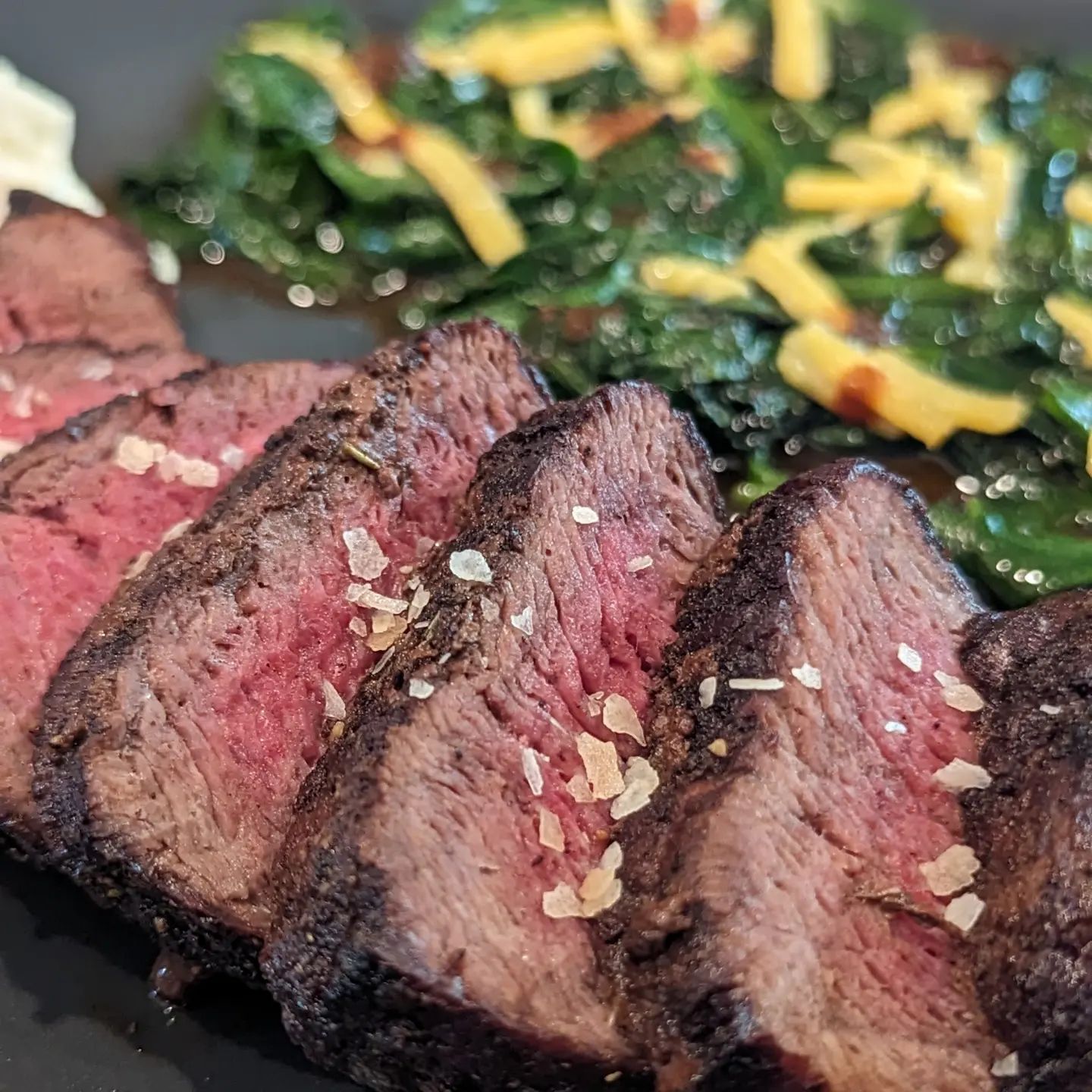 Pan seared steak with a side of spinachIn my @hexclad pan I cooked this @butcher_box sirloin steak seasoned initially with salt only. I seared this on all sides using @chosenfoods avocado oil before lowering the heat and finishing with a butter baste and @neilsarap original beef. As the steak was nearing temp (132f target temp) I tossed in a bit more butter and fresh spinach. The spinach was tossed in the butter, rub and anything else in the pan. To plate, I added a bit of cheese and some chipotle hot sauce to the spinach. The steak was sliced and finished with a smoked flakey salt. Finally I put a scoop of artichoke spinach dip on the side for a little bit of a creamy texture.#steak #steakhouse #steakdinner #panseared #spinach #gourmetmeals #dinnergoals