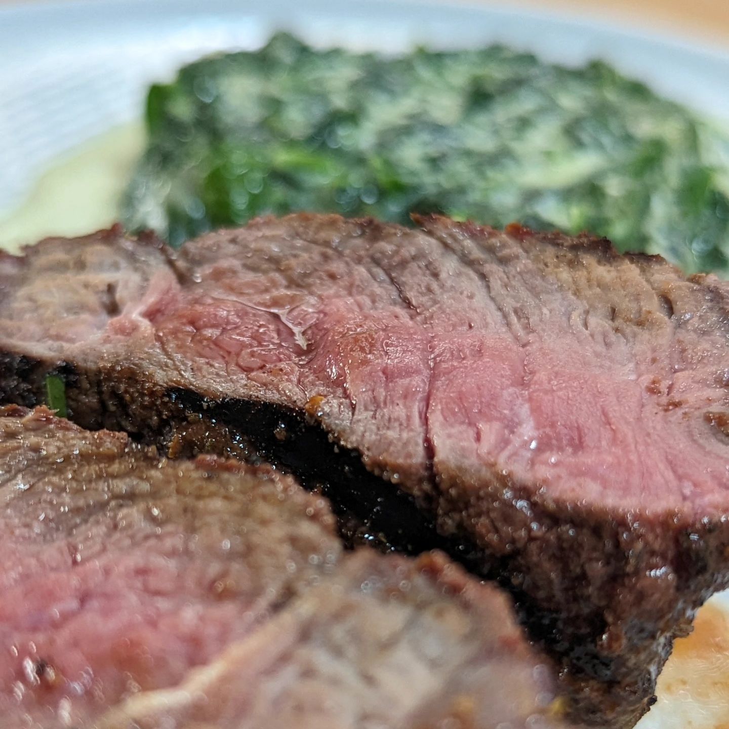 Sirloin steak and spinachI tied these sirloin steaks up and made them feel more like a filet. Seasoned with @neilsarap southwest beef rub and grilled using @bearmountainbbq  hickory pellets. The spinach was sauteed in some butter, heavy cream, mozzarella cheese and seasoned with salt and pepper. On the plate is @bravadospice Serrano basil hot sauce. #steak #sirloinsteak #creamedspinach #grilling #bearmountainbbq #bbq