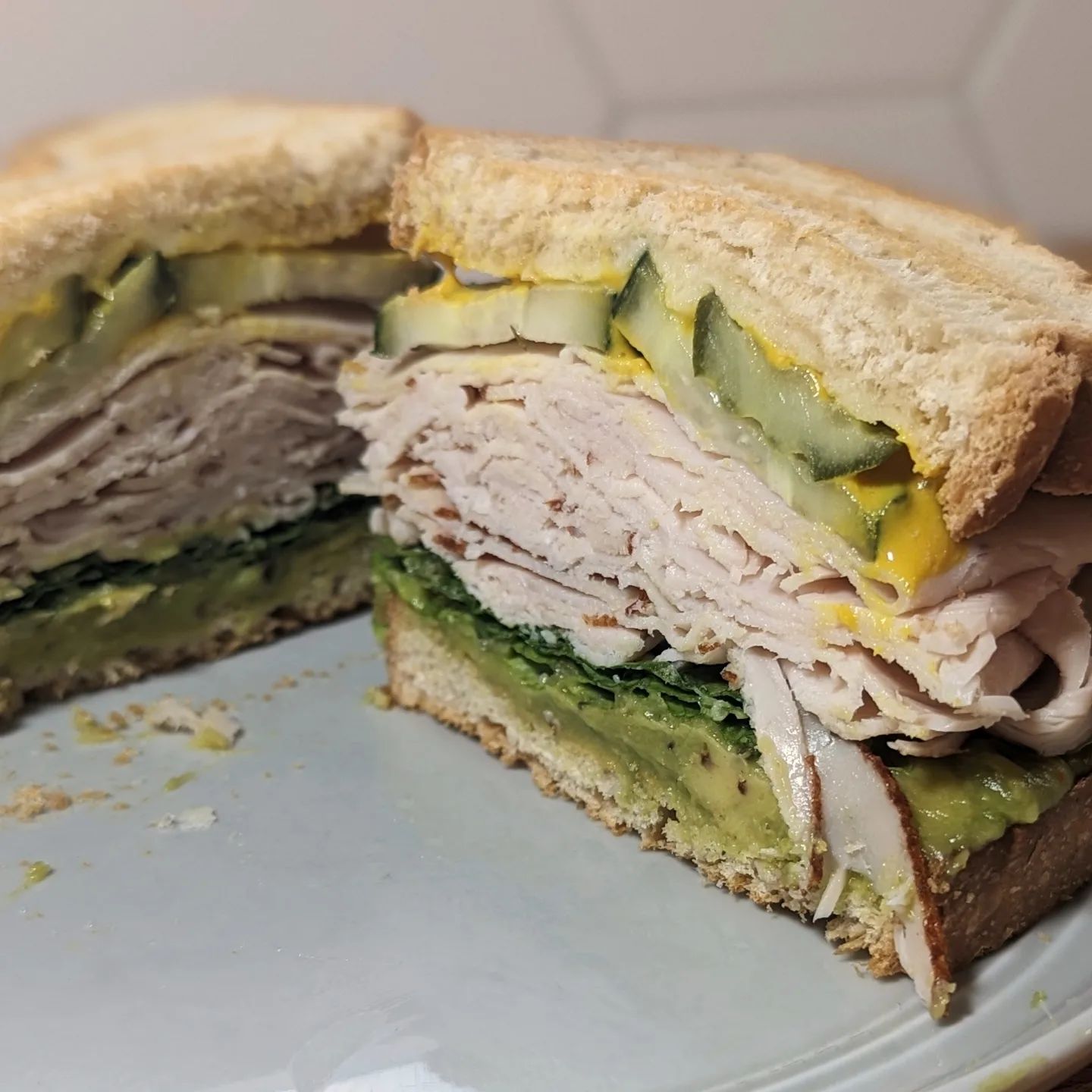 Turkey SandwichKeeping it simple today! Toasted @hero white bread a layer of @eatwholly avocado seasoned with @spiceology guac and roll as well as some @redmondrealsalt ancient grains kosher salt. A piece of romaine lettuce, deli meat turkey, @grillospickles pickle chips, @cabotcreamery cheddar melted on the top bread and a little @frenchs yellow mustard.#sandwichrecipe #sandwichoftheday #turkeysandwich #eaaylunch