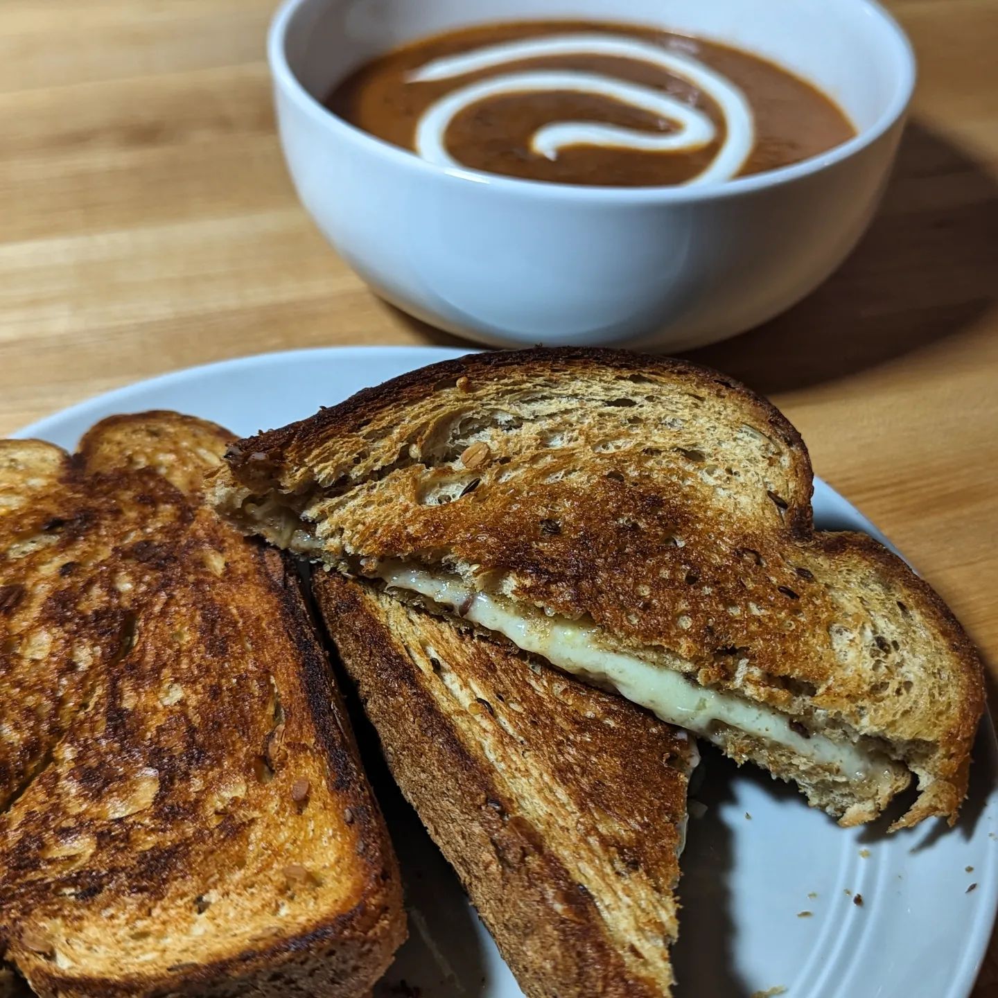 Tomato soup and grilled cheese@eatpropergood makes the soup so easy! Heat and eat tomato soup, with a little sour cream added. The grilled cheese is @hero seeded bread and @cabotcreamery 2 year cheddar cheese, cooked up in a pan with some butter over medium low heat giving that cheese time to get melty while the outside is a perfect golden brown. Perfect dinner on a rare rainy evening in San Diego. #soup #tomatosoup #grilledcheese #soupandsandwich