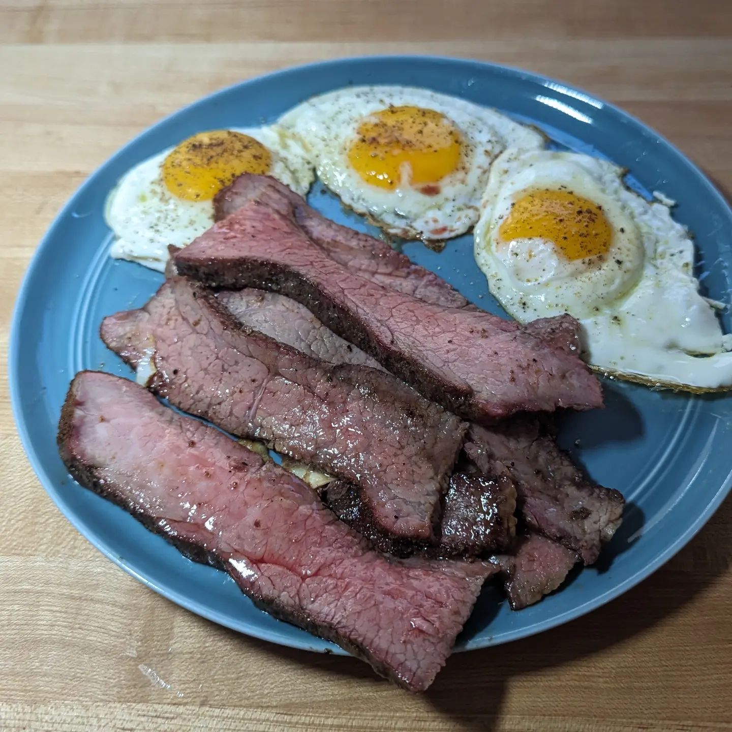 Sometimes you just need a big plate of steak and eggs! Protein for the win here! Sliced up some of the leftover tri-tip. This is the smoked tri tip I made for the tacos, seasoned with @neilsarap wild game rub and cooked with @bearmountainbbq bourbon blend. To reheat it I simply sliced it and tossed it into my @hexclad pan. Once the meat was warmed through I took it out of the pan, bumped up the heat a bit and cracked in 3 eggs. All they needed were some fresh cracked pepper and @redmondrealsalt Super easy meal, filling and delicious!#steakandeggs #carnivore #lunch #tritip #bearmountainbbq #leftovers