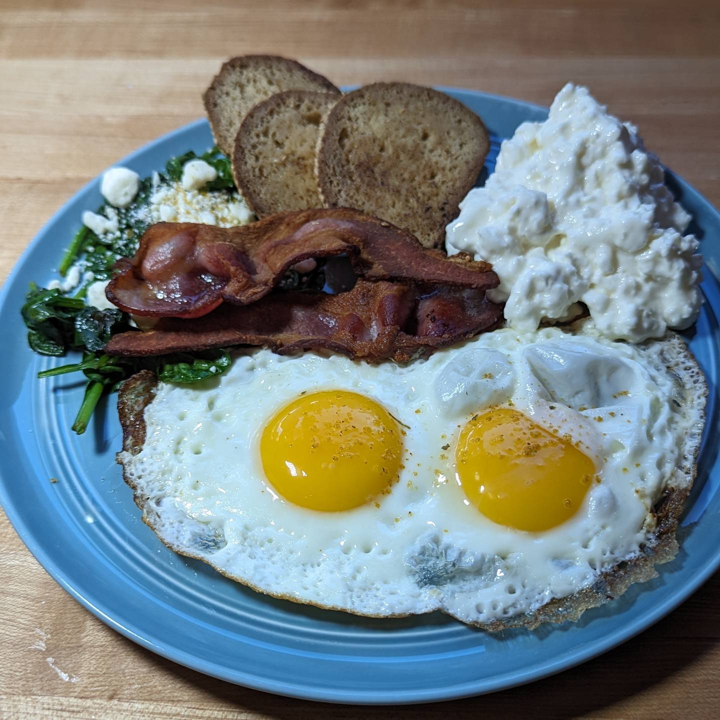 Healthy Sunday Breakfast 2 eggs, 2 slices of bacon, wilted spinach with feta, cottage cheese and of course some fresh @paleotreats baller bread. I visited Lee yesterday at Paleo Treats here in San Diego and picked up a fresh loaf of sesame baller bread, dipped in the bacon fat and toasted, this stuff is as incredible as always. For seasoning on the eggs and spinach, I went simple with @redmondrealsalt seasoning salt.Paired with a latte and I am set for the morning.#breakfastlover #sundaybrunch #sundayvibes #healthybreakfast #toast #baconandeggs #ketobreakfast #spinachfeta #paleotreats